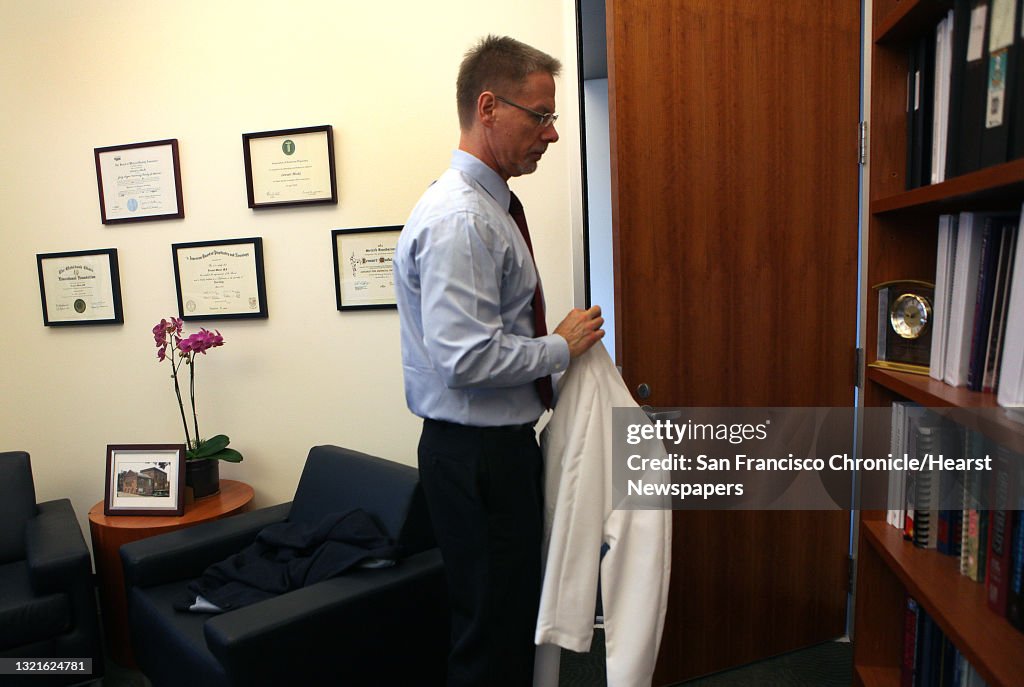 Alzheimer's expert Dr. Lennart Mucke gets his lab coat in his office at Gladstone in San Francisco, California, on Monday, November 18, 2013. He's been studying a protein called beta amyloid, the primary target of Alzheimer's research.