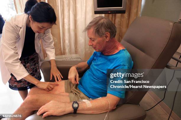 Founder Bernice Kwong, M.D. , of supportive dermato oncology checks the condition of the neck of cancer patient Michael Grupp at Stanford Cancer...