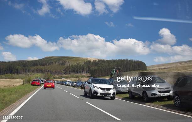 tourists parked on the road verge as they find a place to park as they visit and climb pen y fan the highest peak in south wales in the brecon beacons - grass verge stock pictures, royalty-free photos & images