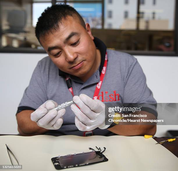 Dish employee Johnson Chuong takes apart an iPhone to fix a cracked screen on site in the Chronicle building in San Francisco, California, on...