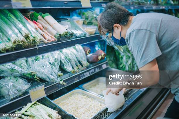 asiatische chinesische mittlere erwachsene frau mit gesicht schild gesichtsmaske abholen sprossen in greengrocer shop supermarkt - sojabohnensprosse stock-fotos und bilder