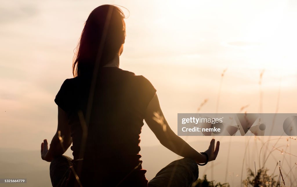 Silhouet van jonge vrouw die yoga in openlucht praktizert