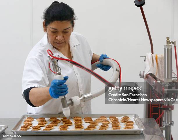 Baker Maria Rodruguez places dulce de leche on the original alfajores at the Wooden Table Baking company in Oakland, California, on friday, may 13,...