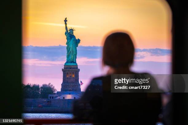 mujer observa la estatua de la libertad - estatua de la libertad fotografías e imágenes de stock
