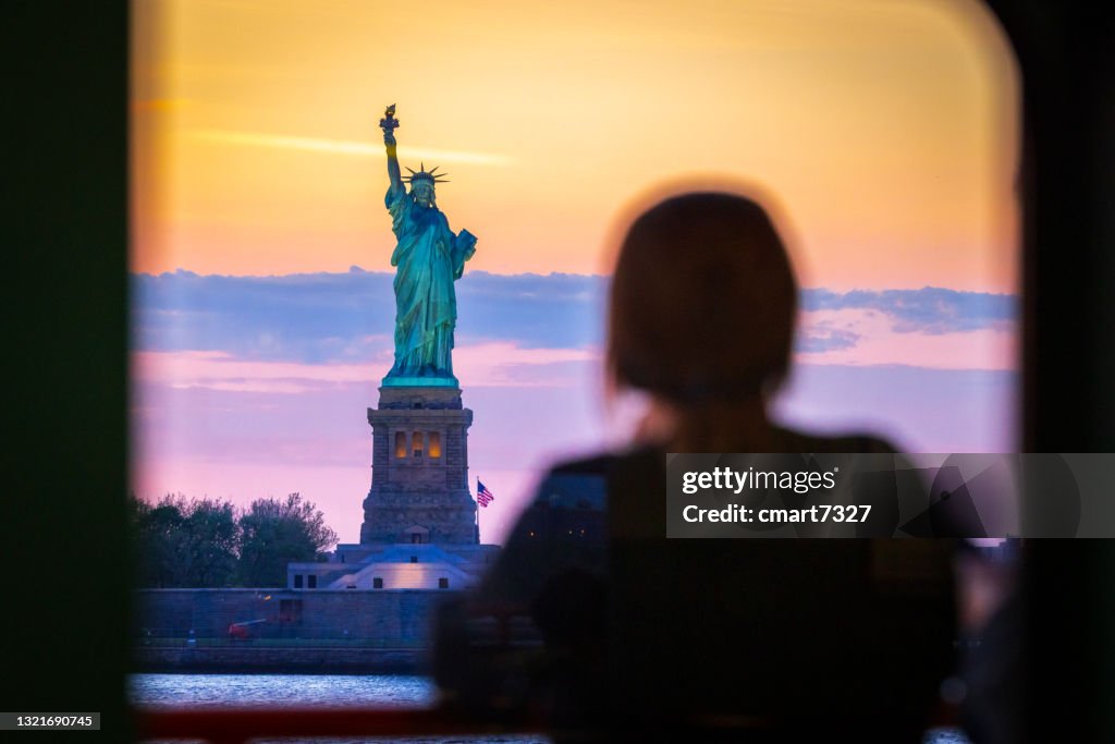 Woman watches the Statue of Liberty