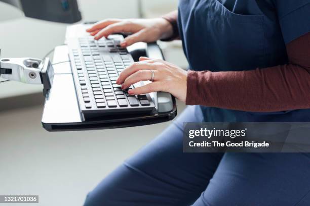 midsection of nurse working on computer in hospital - medical document stock pictures, royalty-free photos & images