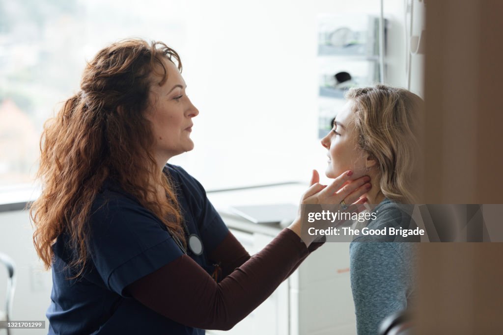 Female doctor examining teenage patient in medical clinic