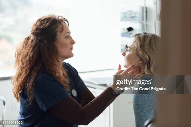 female doctor examining teenage patient in medical clinic - girl medical exam stock pictures, royalty-free photos & images