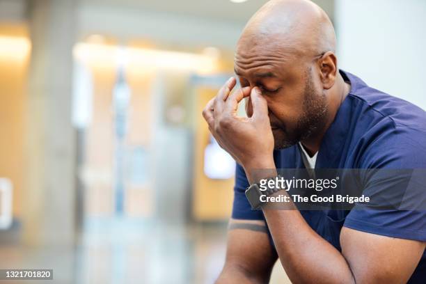 tired male nurse resting in hospital - frustración fotografías e imágenes de stock