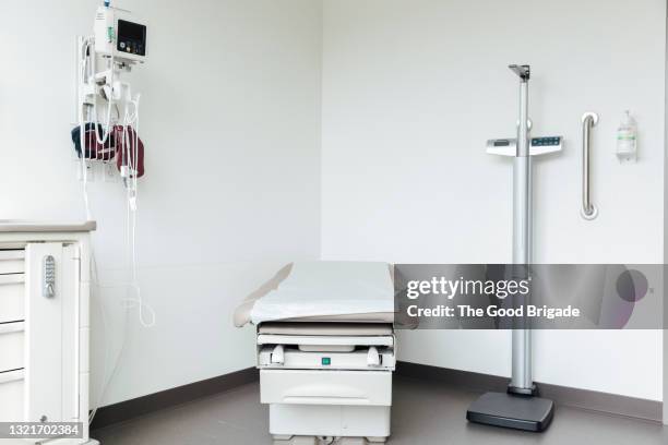 empty bed against wall in medical clinic - examination table stock-fotos und bilder