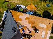 Roof construction repairman on a residential apartment with new roof shingle being applied