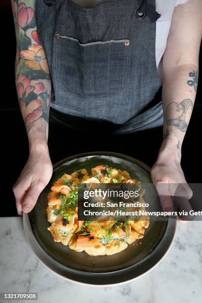 Chef de cuisine Zoe Deegmoked shows salmon, bowfin caviar, creme fraiche, and fines herbes on tater tot waffles at The Riddler on Friday, February 10...