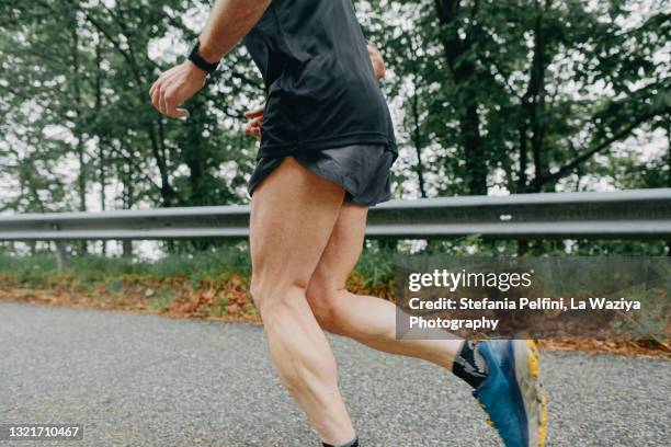 man running on a country road - thigh stock photos et images de collection