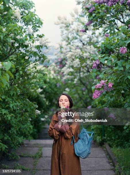 portrait of woman on the background of blooming lilac - kyiv stock pictures, royalty-free photos & images