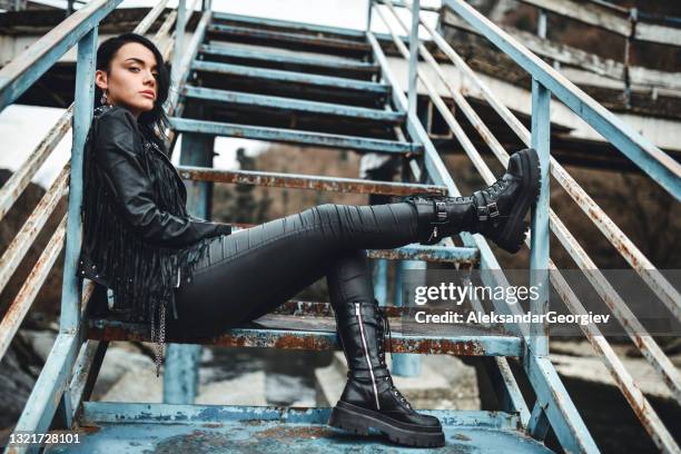 femme steampunk en vêtements en cuir passant une journée paresseuse sur un escalier rouillé - goth photos et images de collection