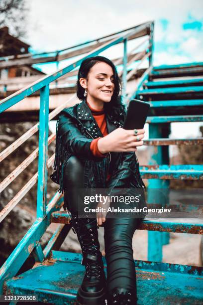 femme gothique souriante prenant selfie avec smartphone sur rusty bridge à l’extérieur - goth photos et images de collection