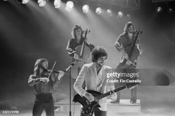 Electric Light Orchestra perform on the set of a video shoot to promote singles from the album 'Discovery' in May 1979. Left to right: Mik Kaminski,...