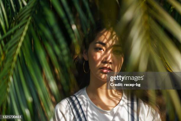 ritratto di bella donna con foglie di palma - viso donna bellezza foto e immagini stock