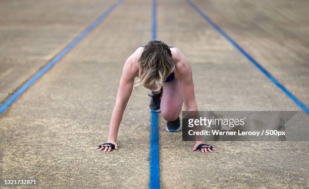 full length of woman exercising on road,belgium - positivism stockfoto's en -beelden