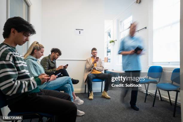 esperando con otros clientes - waiting room fotografías e imágenes de stock