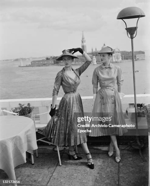 Models wearing Christian Dior fashions near the Piazza San Marco in Venice, 3rd June 1951. The island of San Giorgio Maggiore is visible in the...