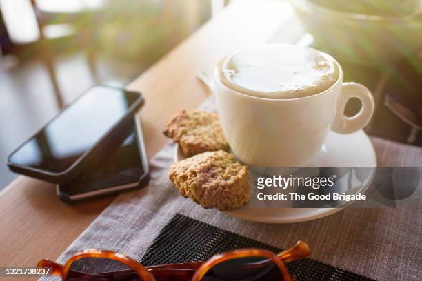 close-up of fresh coffee and scones served by smart phones at table in restaurant - easter_island stock pictures, royalty-free photos & images