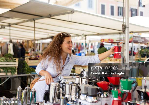 woman buying stovetop coffee maker at the market - town square market stock pictures, royalty-free photos & images