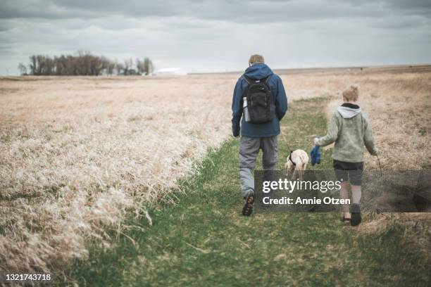 father, son and puppy walk down a prairie trail - prairie dog - fotografias e filmes do acervo