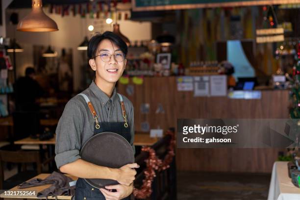 portret van een zekere jonge mens die zich in de deuropening van koffiewinkel bevindt - part time job stockfoto's en -beelden