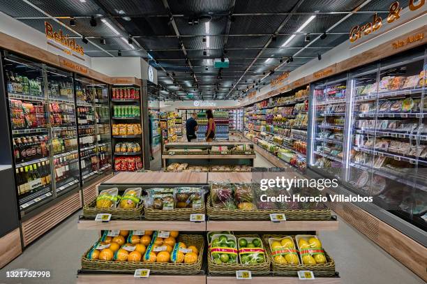 Mask-clad customers shop for products at the "Continente labs" AI supermarket during COVID-19 Coronavirus pandemic on June 04, 2021 in Lisbon,...