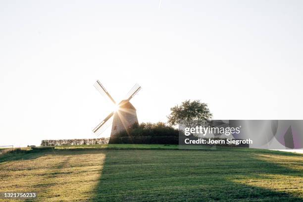 windmühle bei sonnenuntergang - soziales thema stock pictures, royalty-free photos & images