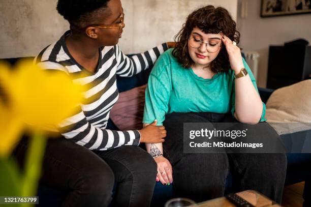 a young woman comforting her friend - comfortable woman stock pictures, royalty-free photos & images