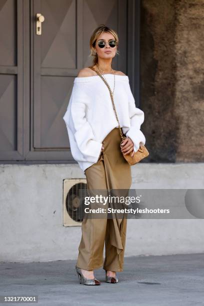 Influencer Gitta Banko wearing a white knitted oversized off shoulder pullover by Simone Bruns, light brown pants by Hellessy, a light brown bag by...