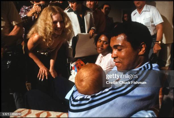 American heavyweight boxer Muhammad Ali holds his infant daughter Laila in his arms as he speaks with members of the press, and others, in his hotel...