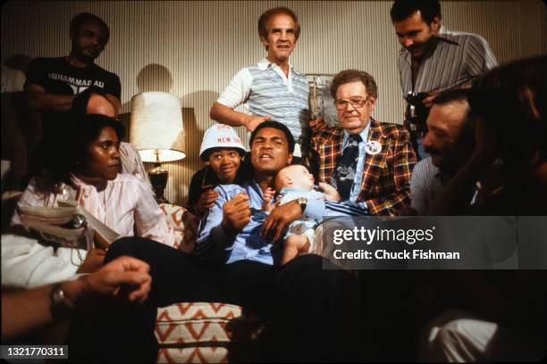 American heavyweight boxer Muhammad Ali holds his infant daughter Laila in his arms as he speaks with members of the press, and others, in his hotel...