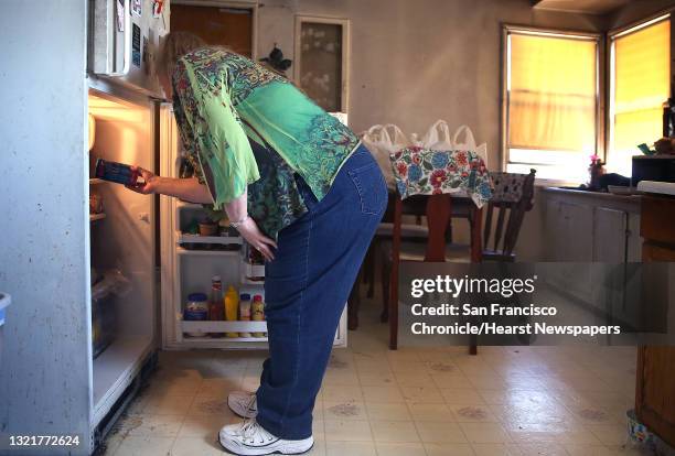 Linda Tollefson, who had a stroke 5.5 years ago, puts away her groceries at home after using a Lyft driver to go to the grocery market on Tuesday,...