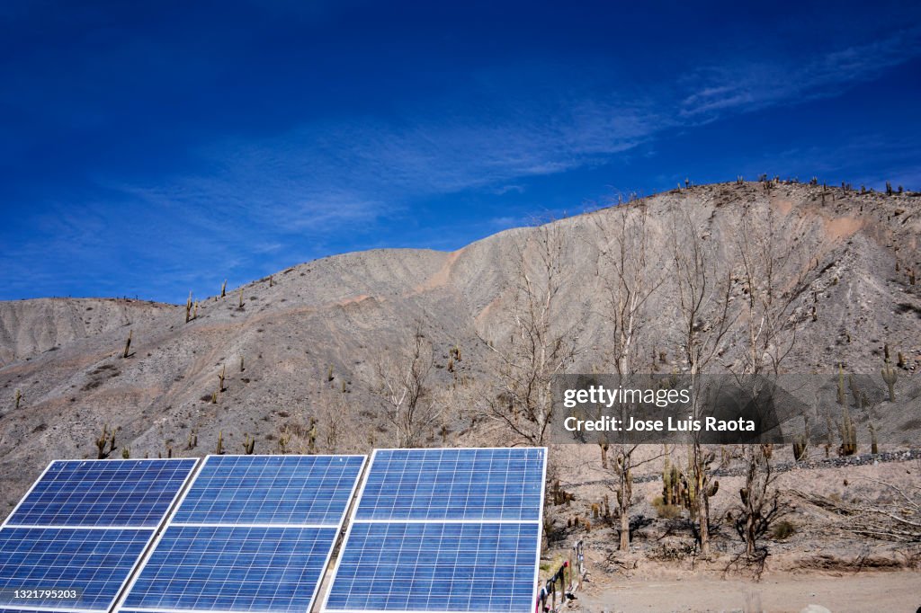 Solar Panel against the blue sky with the view of an Latin American mountain in the background.