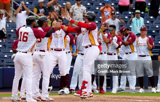 Perez Hernan of Venezuela celebrates with teammates at home plate after hitting a grand slam in the seventh inning against the Dominican Republic...