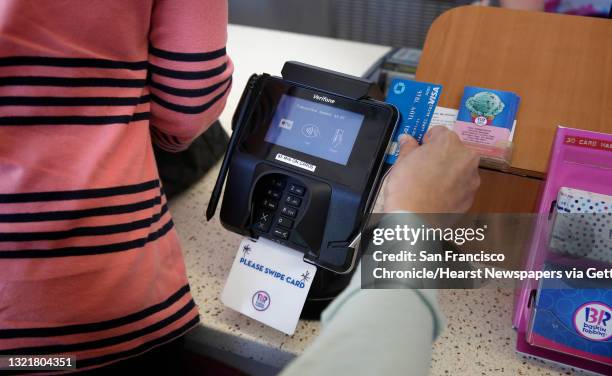 Customers swipe their credit cards through a Verifone device as people enjoy an ice cream at the Baskin Robbins ice cream store in Mountain View,...