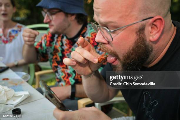 Mike Rothman and friends eat periodical cicadas they prepared as part of the Hot One's challenge at home on June 04, 2021 in Hyattsville, Maryland....