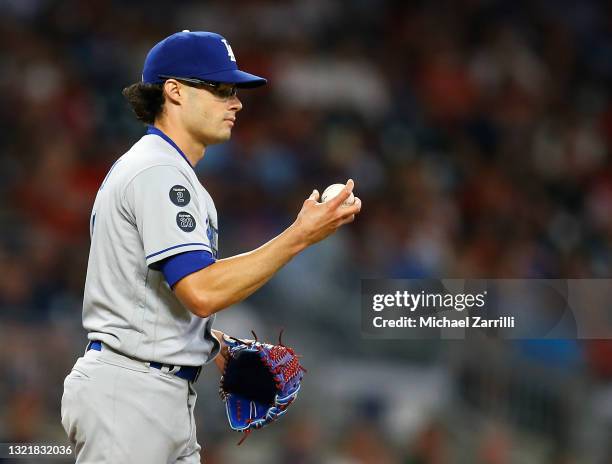 Pitcher Joe Kelly of the Los Angeles Dodgers checks the ball during the game against the Atlanta Braves at Truist Park on June 04, 2021 in Atlanta,...