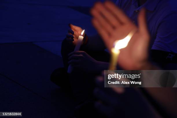 Participants hold lit candles during a candlelight vigil to mark the 32nd anniversary of the June 4th Tiananmen Square massacre at Freedom Plaza June...