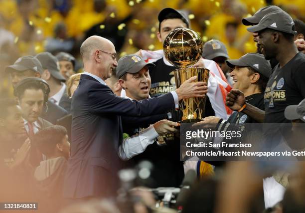 Commissioner Adam Silver presents the championship trophy to Joe Lacob and Peter Guber as the Golden State Warriors beat the Cleveland Cavaliers...
