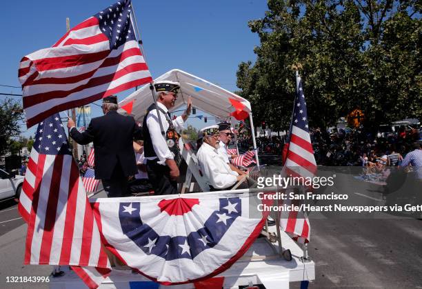 Veterans George Smith, and Fred Martinez, with the Redwood City chapter of the American Legion wave during the annual Fourth of July parade through...