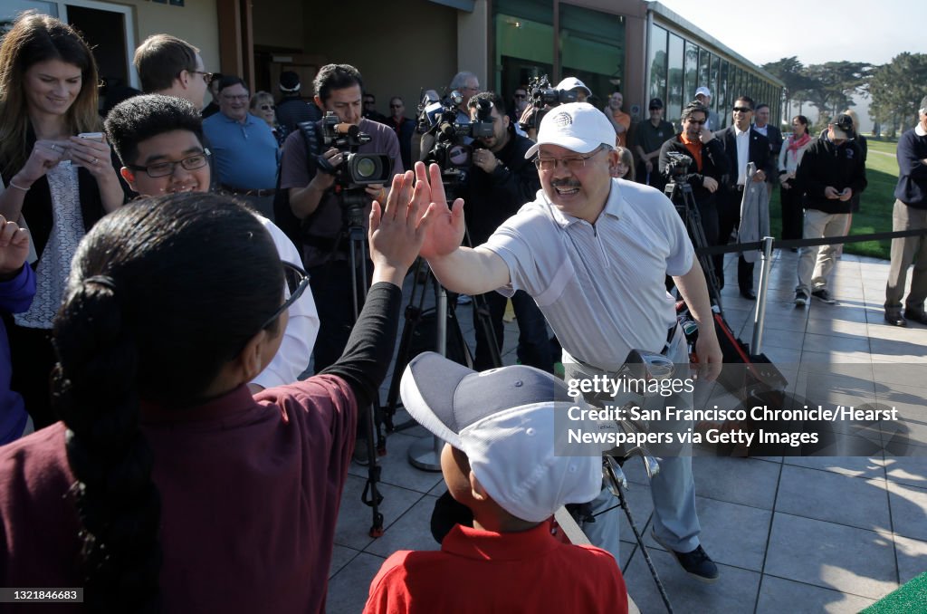 San Francisco Mayor Ed Lee high fives members of the First Tee program,(l to r) Brendan Diaz, 15, Catherine Batang, 13 and Enrico Diaz, 9  on Mon. Feb. 16, 2015 in San Francisco, Ca., during a promotion of the Match Play Championship PGA tour event which