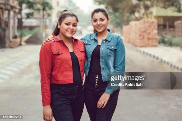 two young asian women having fun at street in city- sisters having fun together. - sibling stock pictures, royalty-free photos & images