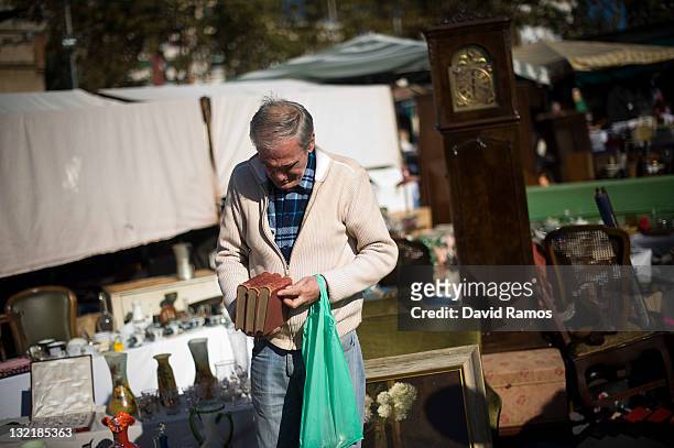 Customer checks some books in a second hand furniture shop at a second hand market on November 9, 2011 in Barcelona, Spain. The current Eurozone debt...