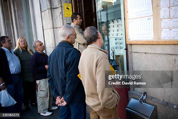 People queue up for buying lottery at a lottery shop on November 9, 2011 in downtown Barcelona, Spain. The current Eurozone debt crisis has left...