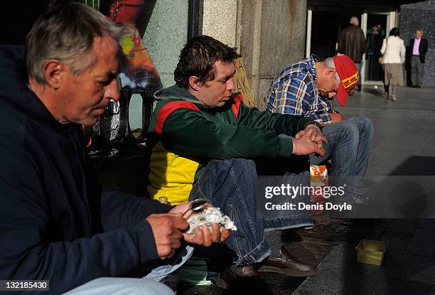 Homeless men from Poland sit on the sidewalk at Puerta del Sol on November 8, 2011 in Madrid, Spain. The current Eurozone debt crisis has left Spain...