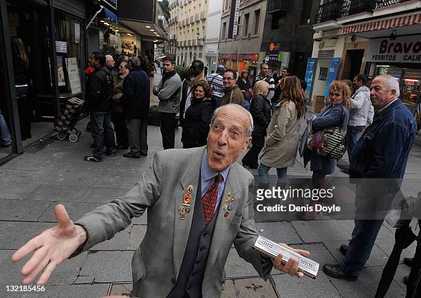 Antonio Garcia performs for people queueing up for El Gordo Christmas lottery tickets on Calle Preciados on November 10, 2011 in Madrid, Spain. The...